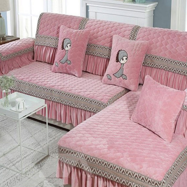 مبل راحتی که با کاور مبلی عروسکی با رنگ صورتی پوشانده شده است.