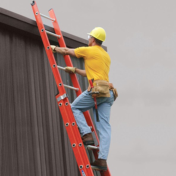 نردبان مخابراتی کشویی به رنگ قرمز و مردی در حال بالا رفتن از آن